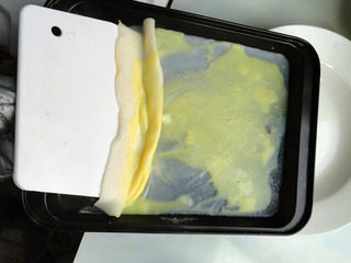 鸡蛋肠粉,取出盘子，用刮板刮出肠粉。按此方法蒸完剩下的粉浆。