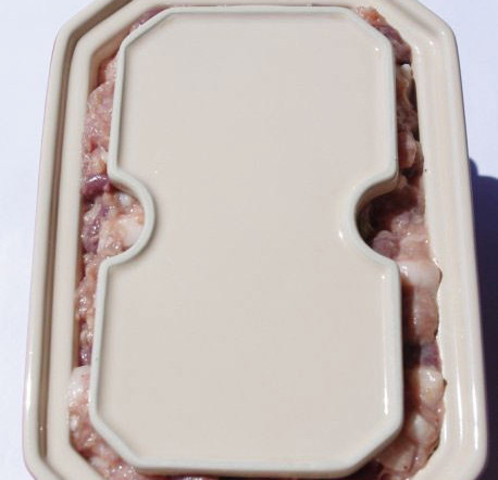 法式猪肝酱,放上盖板（这里没有可以不用），盖上盖子就可以入烤箱了。如果没有这种瓷盅，可以用土司盒代替，但必须要按照土司盒的口径做一块木板或厚纸板，在肉泥烤好后，压制的时候需要用到