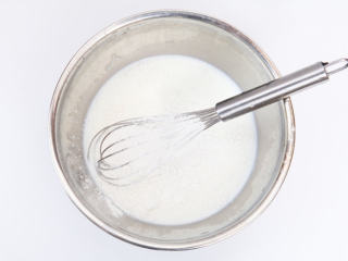 芒果雪媚娘,牛奶，白砂糖加热，至白糖融化后倒入碗内。在碗中加入玉米淀粉，糯米粉100克混合成浆糊状，拌至无颗粒。