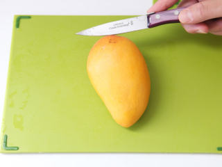 杨枝甘露,取一个芒果沿果核往下切开，切的过程中可自由把握倾斜度，因为果核大小形状不一。