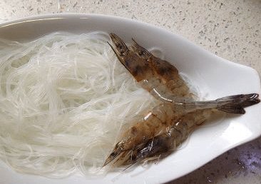 蒜蓉粉丝开片虾 ,一小把白粉丝用温水泡软，沥干铺于盘中，将虾展开铺于粉丝上，如图示；