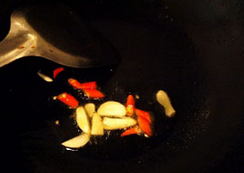 酸辣红菜苔,炒锅放油烧热，下蒜片和小红椒段爆香，倒入红菜苔。