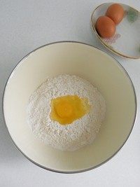 蔓越莓沙琪玛,面粉先打入1个鸡蛋，用筷子将鸡蛋和面粉拌匀，看面粉情况酌情再放1或2个鸡蛋。