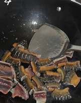 酱烧黄鳝,锅中放油烧热，倒入黄鳝段不断翻炒至表面变色。