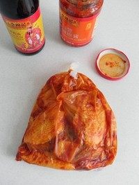 蒜香烤翅,系上袋口，用手来回揉捏，使酱汁均匀的裹在鸡翅上。