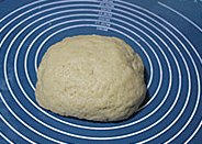 新疆大饼,加入20克牛奶，在案板上揉成光滑面团即可（这一步的牛奶根据面团来，成型的面团是比较软的，湿润但不粘手）。