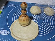 新疆大饼,按压成饼型，馕针扎孔，没有馕针可用叉子。