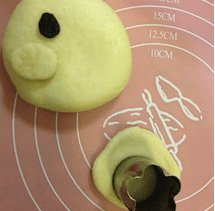 面包超人,将剩余的大面团擀开，用压模压出小的圆形，取3个小圆形面团放在大面团上并用手轻压，使结合紧密。