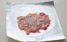 糯米鸡肉卷,将鸡腿肉铺在锡纸的亚光面上，撒少许干淀粉。