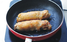 糯米鸡肉卷,取出蒸熟的鸡腿，平底锅中倒少许油，煎至皮金黄即可。