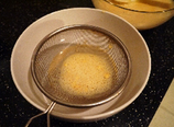 酸辣豌豆凉粉 ,过筛一遍滤去没有化开的粉疙瘩，也可以过筛时用勺子磨一下，把疙瘩充分化开。