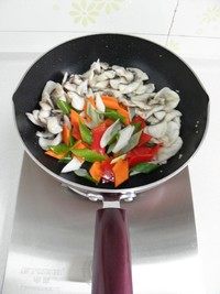 滑炒黑鱼片,将鱼片推至锅边，放入胡萝卜，红椒和葱段，炒出香味。