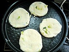 家常葱花油饼,电饼铛刷油放入做好的葱花饼。