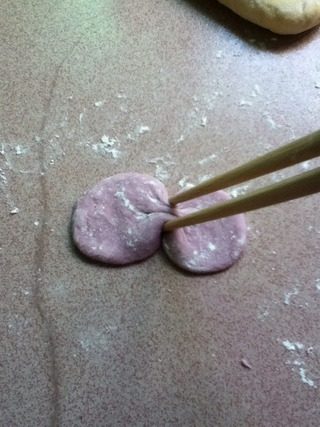 拖鞋面包,再取一点紫面团擀薄圆片，用筷子朝中间夹紧成蝴蝶结。
