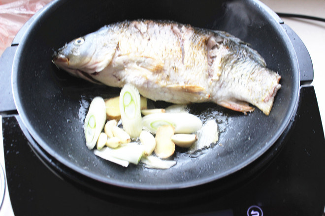 豆腐炖鱼,锅内爆香葱姜，放入煎好的鱼鱼