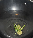 酱爆螺蛳,锅中放油烧热，放入姜片和葱白爆香。