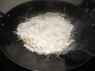 干炒牛河,将锅里的油倒干净，一点都不留，加热锅，将绿豆芽和河粉、洋葱一起入锅。