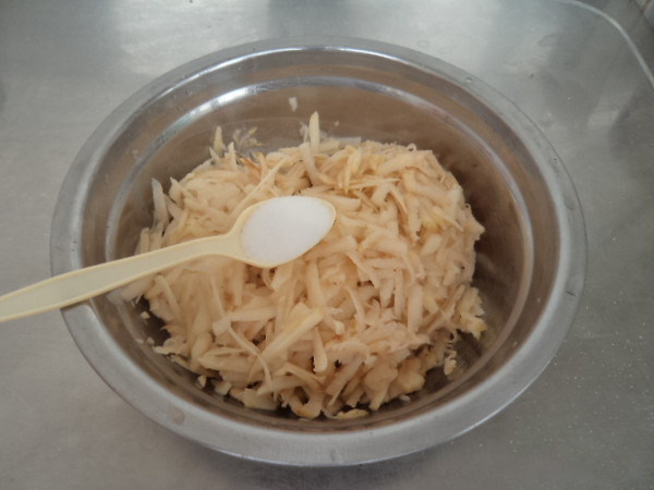 陕北洋芋擦擦,擦碎的洋芋中加盐搅拌均匀