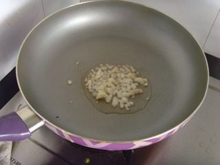 九层塔炒花蛤,锅烧热后放入少许油，姜蒜切末，放入锅中爆香。