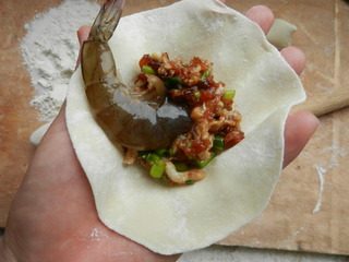 鲜虾凤尾烧麦,取适量肉馅于面皮中央，放上一只虾，虾尾朝外