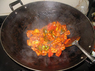 咕噜肉,加入炸好的猪肉后，快速炒匀，令每块猪肉都裹上糖醋汁。