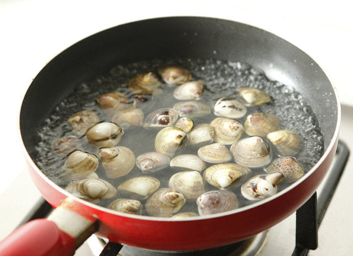 辣爆花蛤,锅内适量水烧开，放入料酒，倒入花蛤。