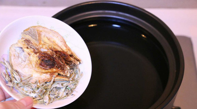 黄豆芽明太鱼汤,锅里放水，加入明太鱼头和小银鱼待水煮沸