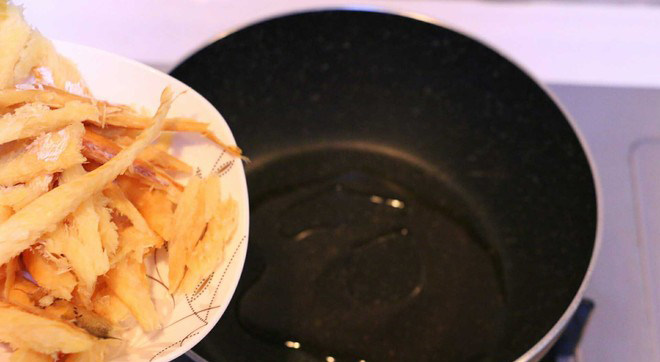 黄豆芽明太鱼汤,另外起锅，放入少量芝麻油加热，加入沥过水的明太鱼翻炒