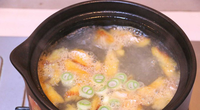 黄豆芽明太鱼汤,沸水中加入炒好的明太鱼和葱，继续煮5分钟