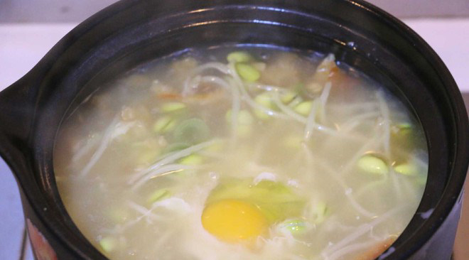 黄豆芽明太鱼汤,煮沸的汤里打入一颗鸡蛋，迅速搅拌