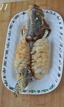 松鼠桂鱼,把炸好的鱼头和鱼身在盘中拼回整条鱼的形状，头部和尾部要翘起。