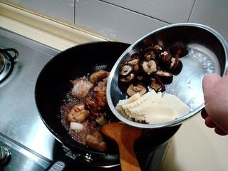黄焖栗子鸡,炒匀后倒入配料香菇和冬笋片再次翻炒均匀。