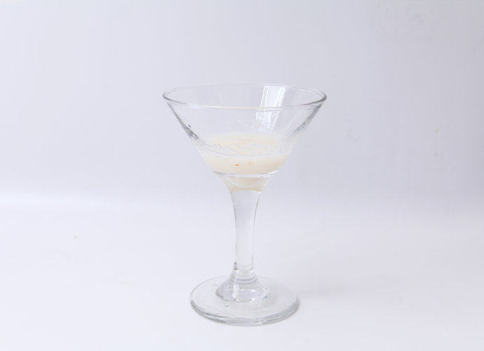 双色荔枝果冻,准备一个干净的玻璃杯，舀取1勺步骤4中的荔枝溶液，倒进杯子里三分之一处，放入冰箱冷藏15分钟至凝固。