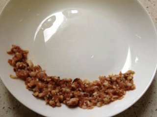萌兔香菇肉末蛋羹饭,加入一小勺冷开水和少许生抽，盐和糖充分搅拌，将馅料铺于平盘的下底部；