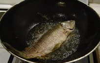泡菜鱼,轻轻晃动锅，让油接触鱼的各个部分，用锅铲将鱼翻面，再炸1分钟左右，捞出，沥干油待用。