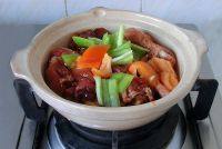胡椒啫啫滑鸡煲,再将腌好的仔鸡块和青、红菜椒2片放入。