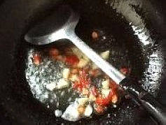 干煸大碗四季豆,锅里放油（ 油稍微多点）将小米椒、干辣椒段和大蒜下锅爆出香 味。