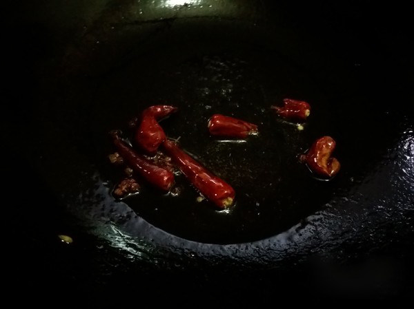 干煸四季豆,锅中留少许底油，放入干辣椒和花椒粒炒香