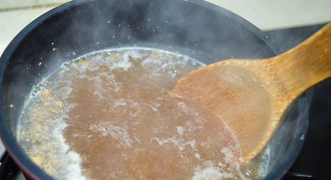 红糖生姜鸡蛋羹,用木勺搅拌一下，转中小火煮3分钟左右