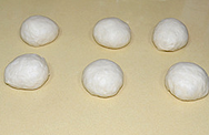 庞多米吐司,将发酵好的面团取出，按压排出空气，分割成6等分，滚圆盖上保鲜膜松弛15分钟。