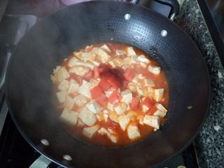 番茄豆腐,炖至汤汁收浓，再放入剩余的番茄块和番茄酱。