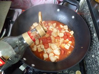 番茄豆腐,加入酱油、白糖、鸡精小心炒匀。