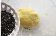 黑芝咸香麻饼干 ,倒入熟黑芝麻，轻揉至均匀的分布在面团里。