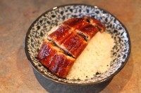 蒲烧鳗鱼饭,将微波炉叮好的鳗鱼切段，铺在米饭上