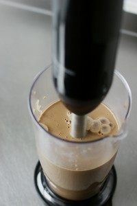 咖啡香蕉冰淇淋,香蕉剥皮切块和煮好的浆料一起倒入搅拌机桶内，将它们充分打到均匀细腻即可。