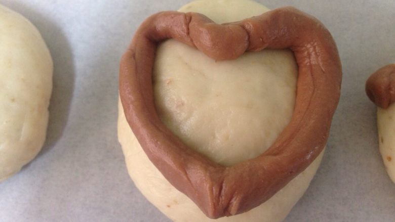 椰香萌猴面包（超详细做法）,把细长条放在白面团上，整理出一个爱心形。