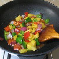 泰式菠萝虾球,放入彩椒翻炒均匀，放入菠萝翻炒均匀。