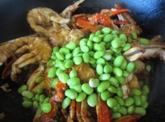 面拖蟹,加入事先烫熟的毛豆，翻匀，点入少许水，加锅盖焖片刻