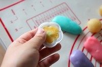 立体月饼,再取些黄色冰皮按扁放在花心上中间凹槽里捏进去，大拇指粘熟粉按不会粘。