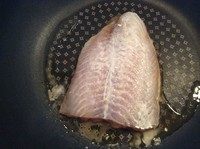 黄油龙利鱼,将龙利鱼放入锅内小火煎3到4分钟。